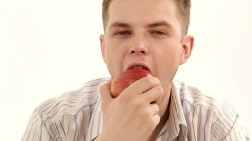Man Eating a Delicious Red Apple on White Background