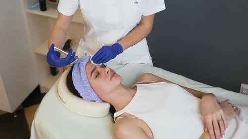 Female Cosmetologist Hands Making Beauty Injection for Young Attractive Woman
