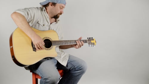 Man Plays Acoustic Guitar in Studio