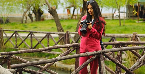Woman Checks Photos on Camera in Nature Park
