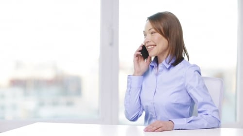 Woman Talking on Cellphone in Bright Office