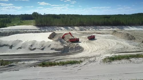 Camera Rises Above Sand Pit with Excavator and Dump Trucks