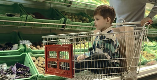 Boy Rides Shopping Cart in Grocery Store
