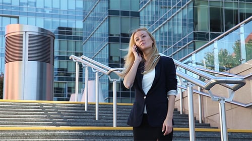 Young Woman Standing on the Stairs and Talking on