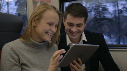 Couple Using Tablet Inside of Train Cabin
