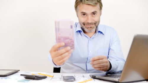 Man counting Euro bills at desk