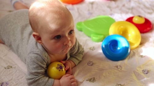 Adorable Infant Playing with Colorful Toys at Home