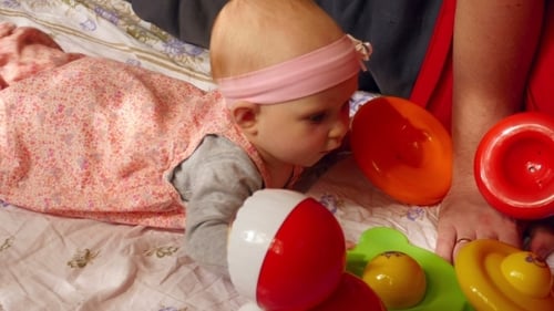 Baby Playing with Colorful Toys on Blanket