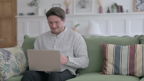 Man Frustrated While Working on Laptop at Home