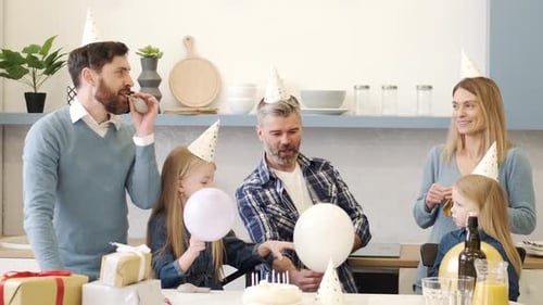 Family Celebrates Birthday with Balloons and Cake at Home