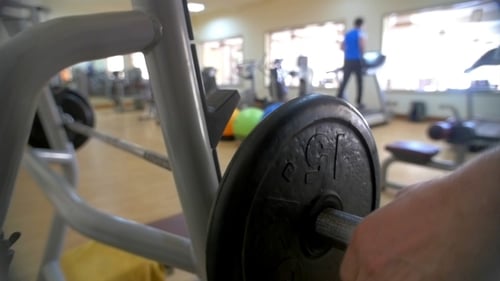 Man Increasing Weight On Barbell