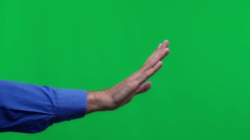 Close Up of Male Hand in Stop Position on Isolated Green Background