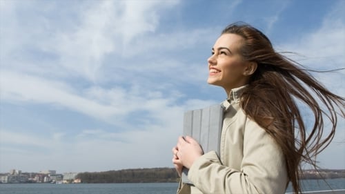Young Woman Using Tablet Outdoors on Sunny Day