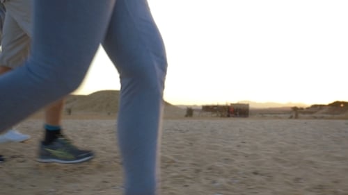 Four Adult People Jogging On The Beach