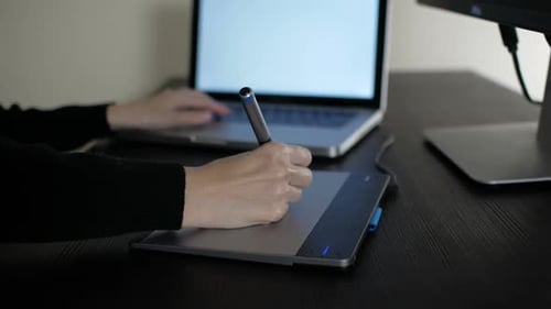 Person Uses Graphics Tablet at Computer Desk