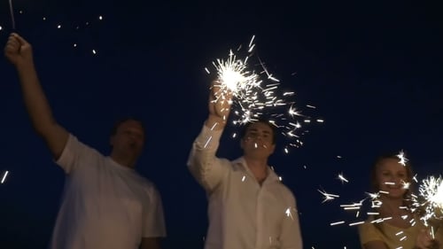 Adults Celebrating with Sparklers at Night