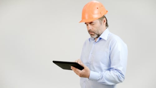 Adult Worker Uses Tablet Wearing Hard Hat