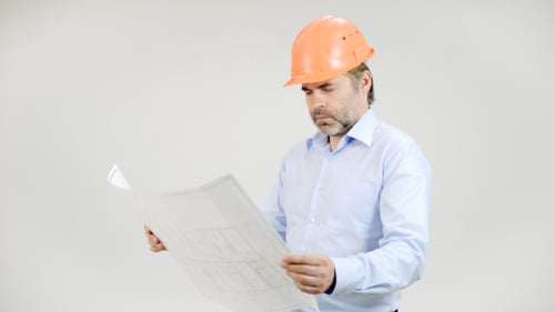 Engineer Looking at Blueprint Wearing a Hardhat