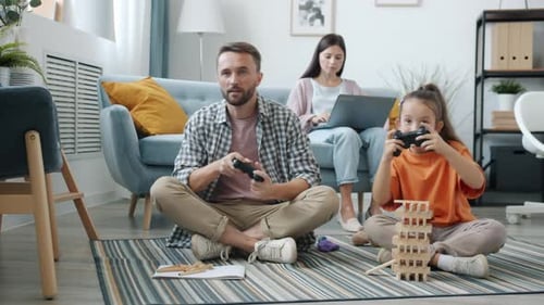 Father and Daughter Playing Video Game at Home