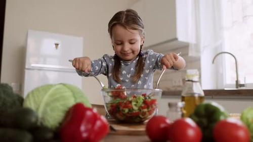Child Mixing Fresh Salad Ingredients in Kitchen