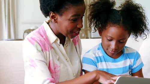 Woman and Child Using Laptop Together at Home