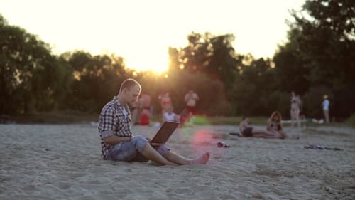 Guy Working With Laptop on the Beach