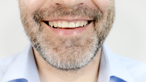 Man Smiles Up Close With Beard Detail