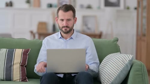 Young Man Closing Laptop Going Away From Sofa