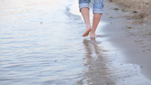 Bare Feet Walking on Beach at Water's Edge
