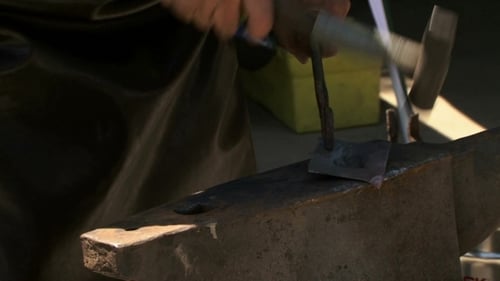 Blacksmith Shaping Metal with Anvil and Hammer