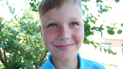 Boy Looks At The Camera And Smiling