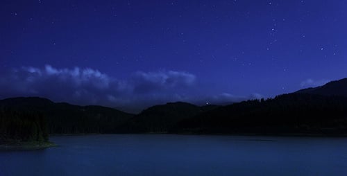 Stars Moving In Night Sky Over Mountain Lake