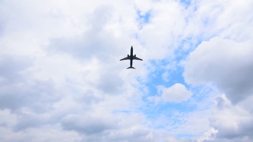 Plane Flying Across a Cloudy Sky