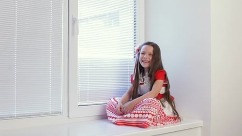 Girl Laughing on Window Ledge Indoors