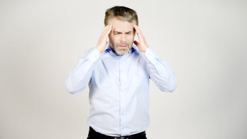 Man Pressing Temples Suffering Headache in Studio