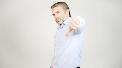 Man Giving Thumbs Down on White Background