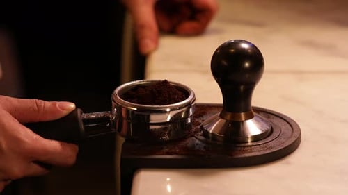 Adult Prepares Coffee with Espresso Tamper