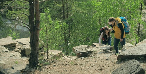 Young Couple Hiking Together Through Mountain Forest