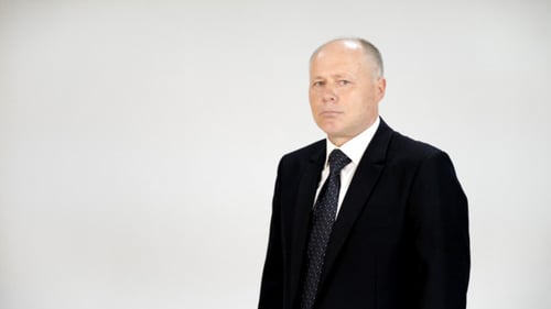 Professional Man in Black Suit Poses on White Background