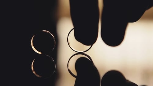 Male Hand Takes Two Wedding Rings