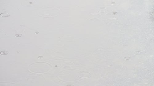 Regen tropft durch die Pfützen
