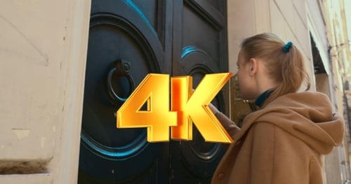 Young Woman Unlocks Door in City Street