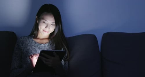 Woman use of tablet at home in evening