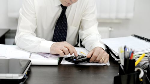 Calculator, Currency, and Papers on Desk