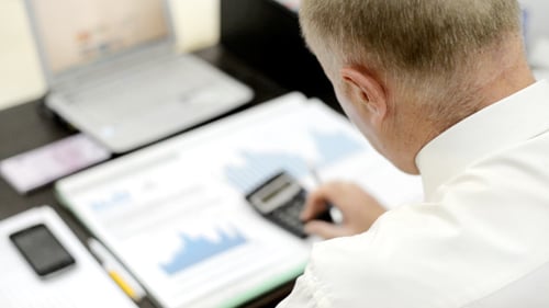 Analysing Business Reports at Desk in Office