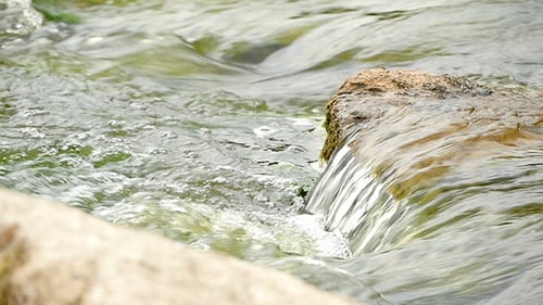 Fast Flowing River With Stones In The Water