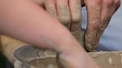 Mains de femmes fabriquant une tasse en céramique sur le tour de potier
