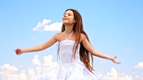 Joyful Child Dancing in Field Under Blue Sky
