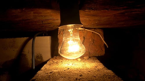 Illuminated Lightbulb in Dark Basement Close Up