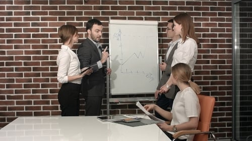 Businessman Giving a Presentation On Flipchart